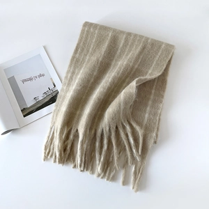 Detail shot of the beige wool-blend plaid scarf featuring a soft mohair texture and long tassels