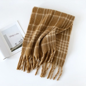 Detailed texture of thick brown plaid wool scarf with decorative soft fringe edges