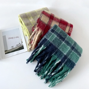 Détail d'écharpes en laine à carreaux avec texture mohair douce et détails de longs franges