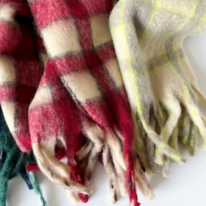 Gros plan d'écharpes épaisses en mohair à carreaux avec texture douce et longs franges