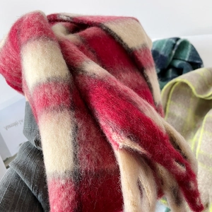 Gros plan d'une écharpe épaisse en mohair à carreaux rouge et beige et texture pelucheuse