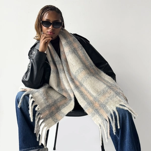 Detail view of plaid winter scarf with long tassels showing premium wool texture and pattern