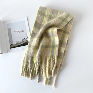 Gros plan sur l'écharpe en laine à carreaux jaune et gris avec de longues franges déco