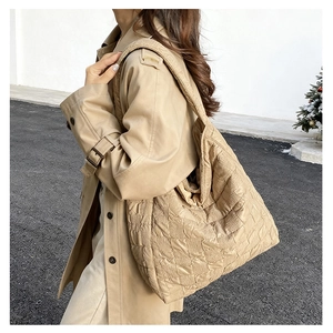 Detail view of quilted khaki tote bag showing textured fabric and spacious casual design