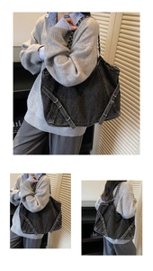 Detail of black denim tote bag with metal chain strap and decorative cross straps
