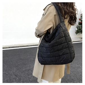 Side view of black quilted tote bag showing large capacity and soft padded texture