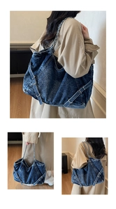 Detail of vintage blue denim tote bag featuring decorative metal buckles and chain straps