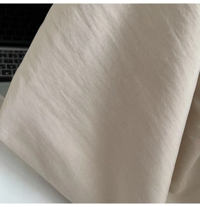 Macro shot of smooth champagne satin fabric with soft silk texture and metallic sheen
