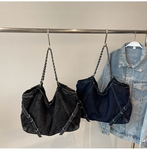 Detailed view of large denim tote bags in black and navy with metal chain straps