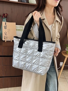 Sac cabas matelassé argenté pour femme avec anses noires dans un style de vie moderne