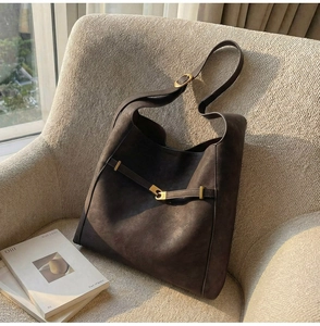 Detail of vintage brown bucket bag with gold buckle on a minimalist sofa chair
