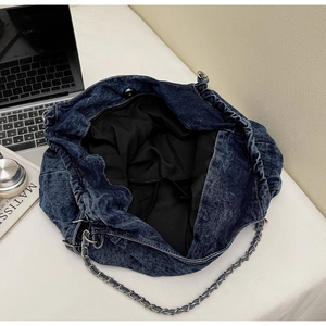 Detailed interior of a navy denim tote with drawstring closure and chain strap