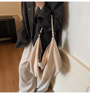 Detail of hobo bag with knotted shoulder strap and dark brown wooden bead accents