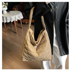 Quilted tote bag detail showing khaki pleated texture on a large shoulder bag for women