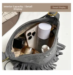 Vista detallada del interior de un bolso bandolera gris con flecos y cremallera de metal