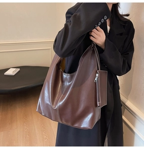 Détail du sac cabas marron foncé avec surpiqûres contrastées et petite pochette zippée