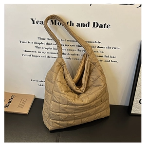 Macro detail of beige quilted tote bag showing square stitching and soft nylon texture