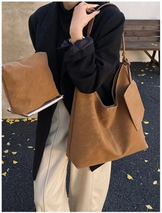 Brown suede tote bag with white contrast stitching and a small matching pouch in fall setting