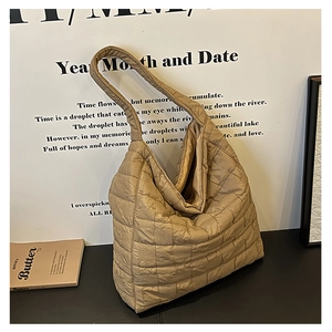 Detailed close-up of khaki quilted puffer tote bag with classic square stitching pattern