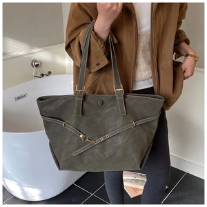 Detail van donkergroene shopper met gepolijste gouden hardware en verstelbare gespriem