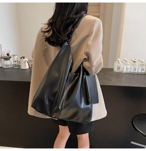 Détail d'un grand sac cabas noir avec coutures contrastées et petite pochette pour le quotidien