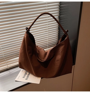 Detail of dark brown tote bag with natural fabric texture and decorative wooden beads