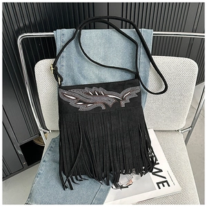 Détail du sac bandoulière en daim noir avec broderie plume et longues franges de style