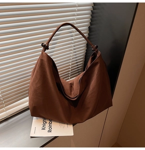 Detail of dark brown Hobo bag featuring matte nylon fabric and wooden bead strap decoration