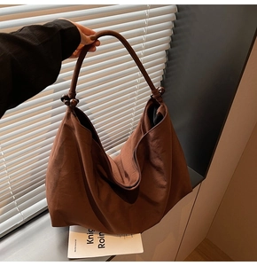 Detail of dark brown hobo bag with vintage wooden beads and soft matte texture