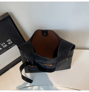 Top view showing the large capacity interior of a black tote bag with camel lining