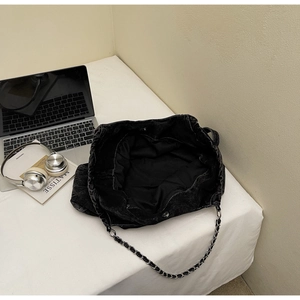 Top view of large black washed denim tote bag with silver chain strap and spacious interior