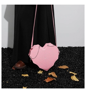 Detailansicht der rosa herzförmigen Tasche mit weißen Spinnennetzen und silberner Kette
