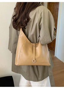Détail du sac cabas en cuir chameau clair avec texture froissée et boucle métallique ronde