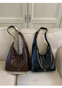 Gros plan de sacs hobo rétro en cuir marron foncé et noir avec boucles argentées