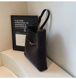 Detail view of large dark brown suede tote bag featuring premium gold hardware and side clasp