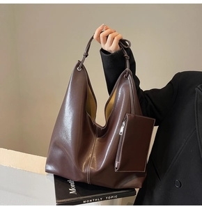 Détail de cabas en cuir marron foncé avec surpiq coutures blanches et petite pochette