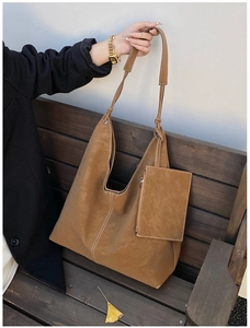 Close-up of brown tote bag showing contrast white stitching and matching zipper pouch