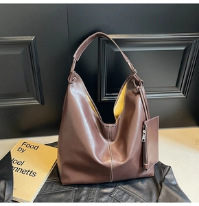Détail du sac cabas en cuir marron avec doublure jaune et pochette zippée assortie