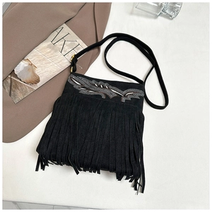 Detalle de bolso de hombro bohemio en ante negro con flecos y bordado de alas