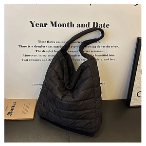 Close-up of black quilted tote bag texture with 3D puffer checkerboard pattern details