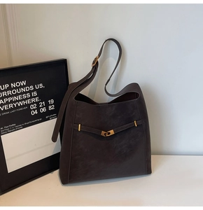 Detail of dark brown suede hobo bag featuring metal buckle and adjustable strap