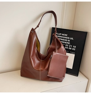 Detail of dark brown tote bag showing glossy PU leather texture and mini zip pouch attachment