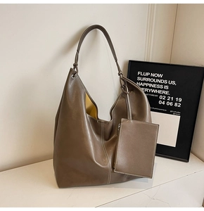 Detail of coffee leather tote bag with white stitching and yellow inner pouch