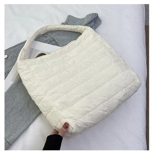 Detail of the white quilted puffy tote bag featuring 3D grid texture and cloud-like fabric