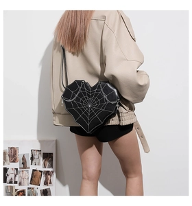 Detail einer schwarzen herzförmigen Gothic-Tasche mit Spinnennetz und silberner Kette