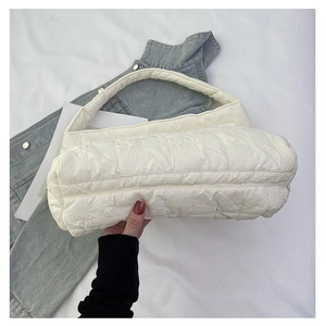 Detailed view of cream quilted tote bag featuring textured 3D square cloud pattern fabric