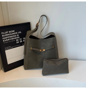 Detail of gray large bucket tote bag with matte leather texture and small pouch