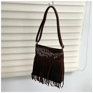 Detalle de bolso bandolera de ante marrón con bordado retro y flecos largos de estilo boho