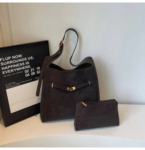 Detail view of large dark brown suede tote bag and matching pouch with gold metal hardware
