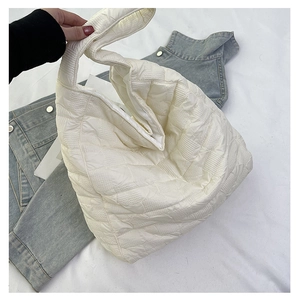 Close-up of white quilted tote bag with square pattern texture and puffy padded material